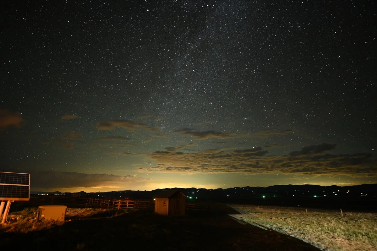 Panneau solaire la nuit sur toiture résidentielle sous étoiles