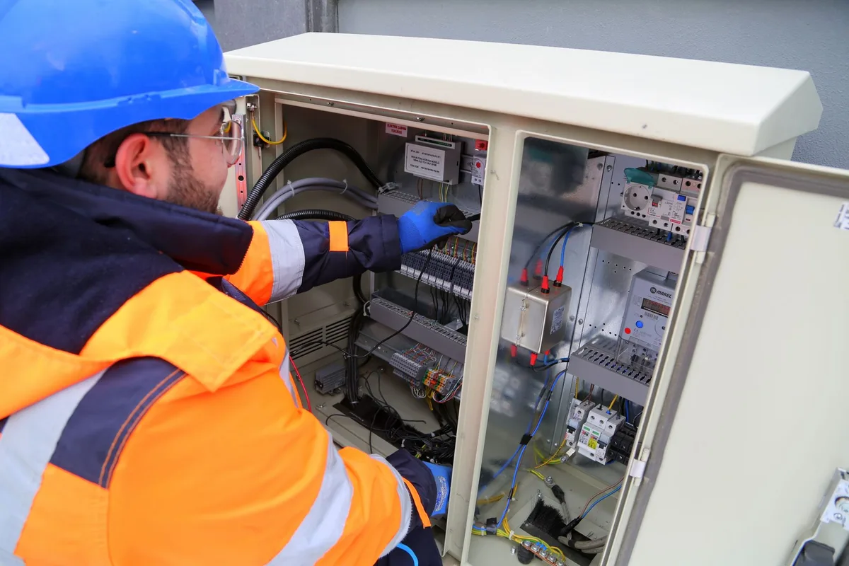 Électricien intervenant sur un tableau de répartition