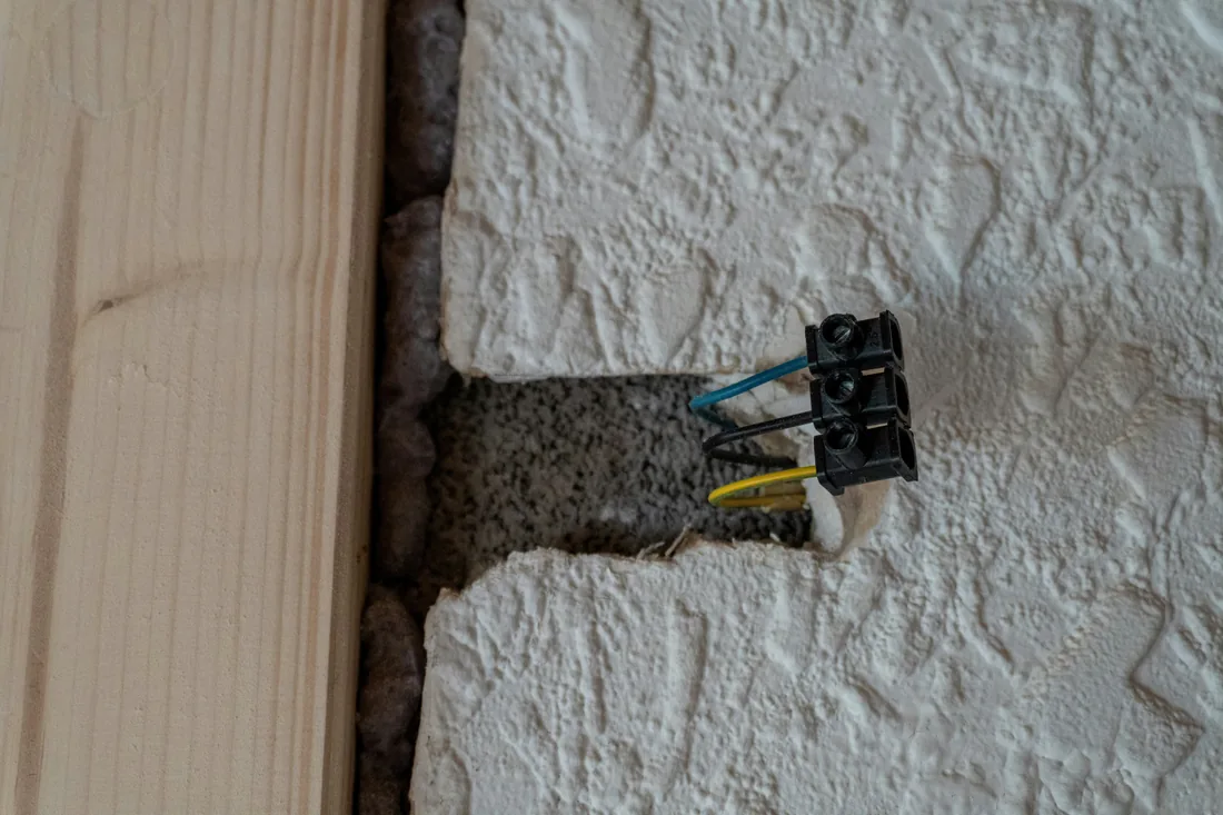 Moulure électrique discrète au-dessus d’une plinthe dans une pièce rénovée
