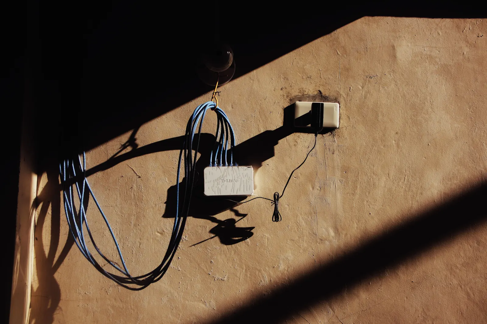 prise extérieure étanche installée sur un mur de maison côté jardin
