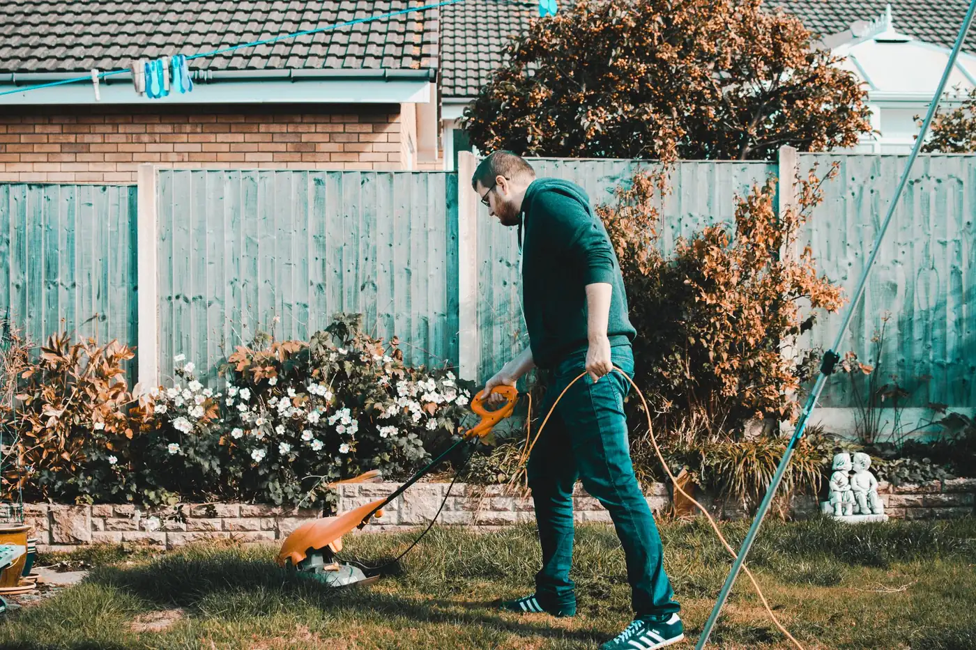 rallonge électrique extérieure alimentant une tondeuse dans un jardin résidentiel